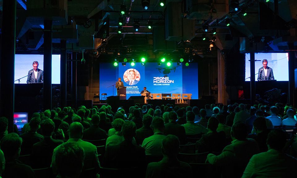 Person presenting in front of large group of people at an event